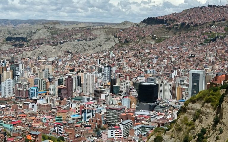 A panoramic view of La Paz, Bolivia, featuring densely packed buildings and mountains.